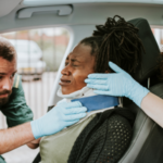 Paramedic placing a cervical collar to an injured woman from car accident